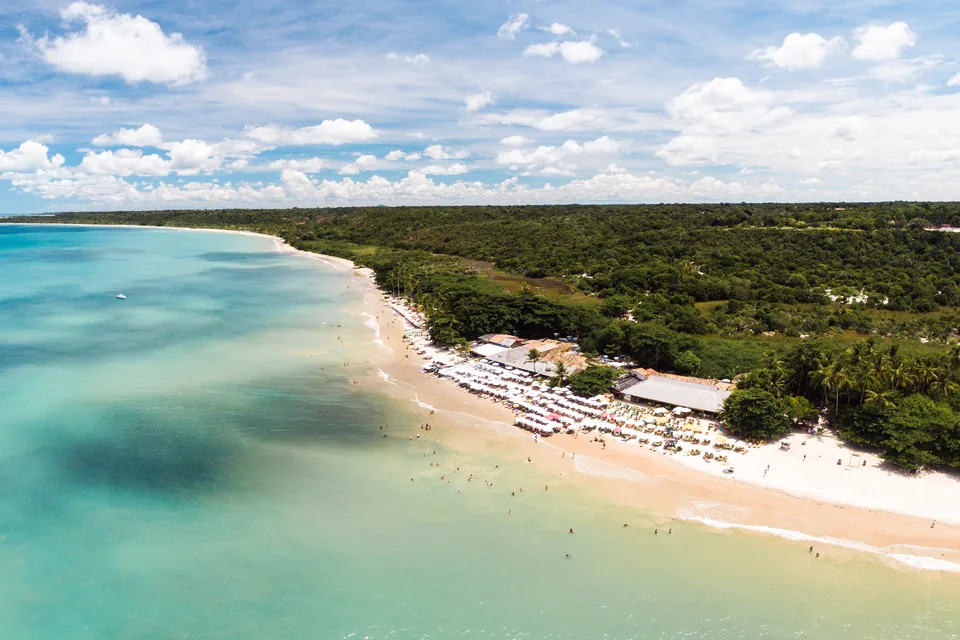 Vista aérea de la Praia dos Coqueiros en Trancoso, con agua turquesa, arena clara y vegetación tropical
